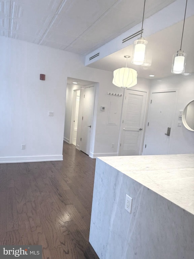 kitchen featuring hanging light fixtures and dark wood-type flooring