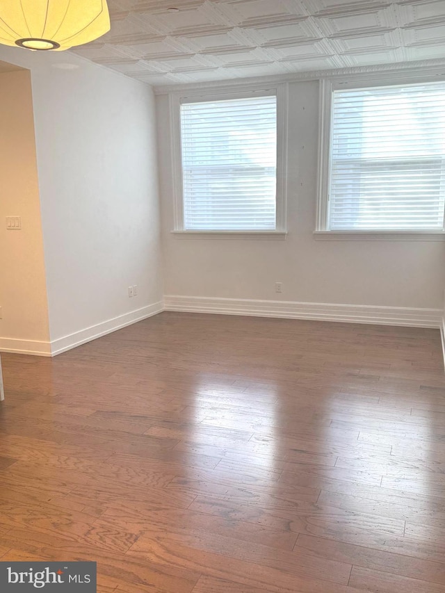 unfurnished room featuring wood finished floors and baseboards