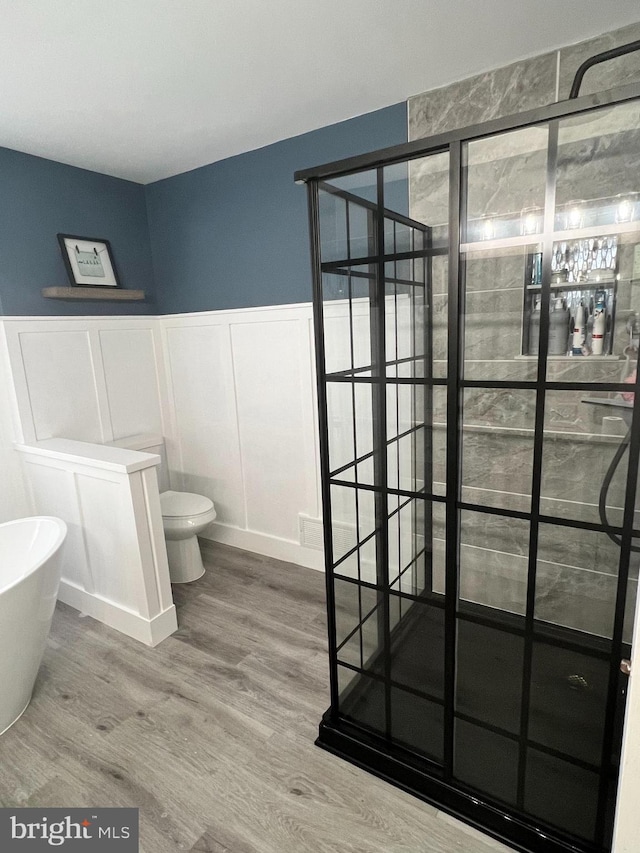 bathroom featuring toilet, independent shower and bath, and hardwood / wood-style flooring