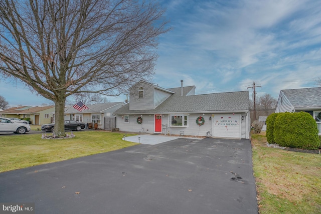 new england style home featuring a front lawn and a garage