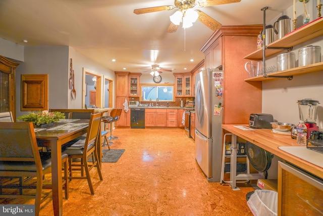 kitchen with stainless steel fridge, tasteful backsplash, ceiling fan, sink, and black dishwasher