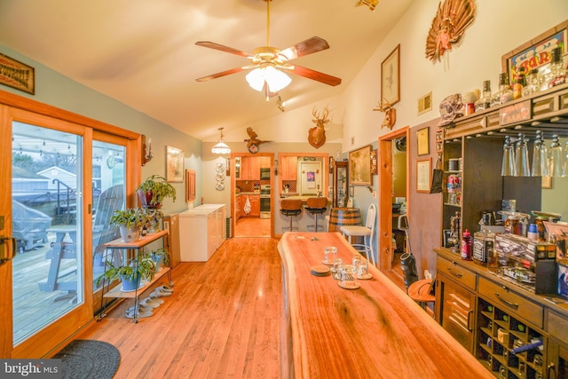 dining area featuring light hardwood / wood-style floors, ceiling fan, and lofted ceiling