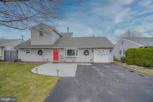 view of front of home with a front yard and a garage