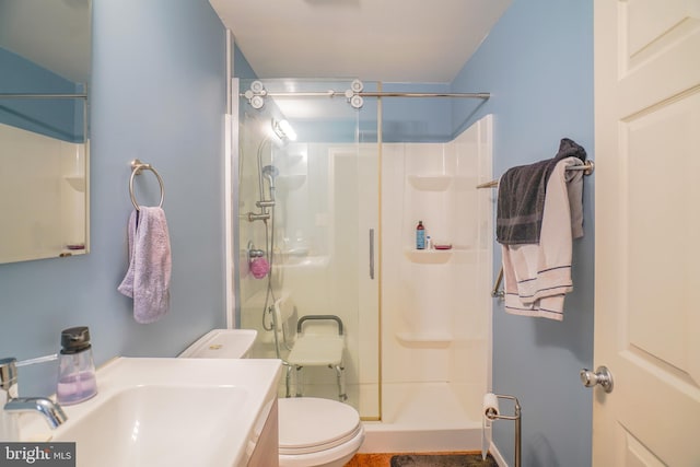 bathroom with toilet, walk in shower, and sink