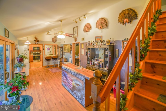 living room with ceiling fan, wood-type flooring, and lofted ceiling