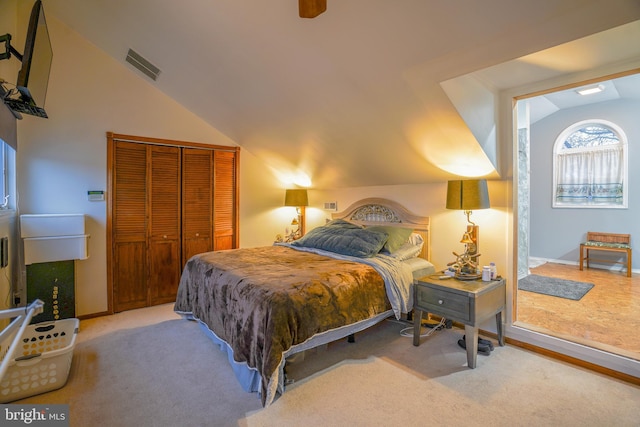 bedroom featuring light colored carpet, vaulted ceiling, a closet, and ceiling fan