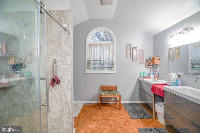 bathroom featuring vanity, a shower with shower door, and lofted ceiling