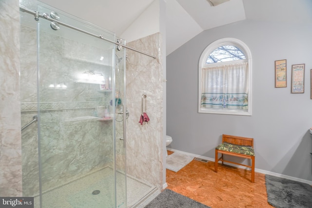 bathroom with toilet, a shower with door, and vaulted ceiling