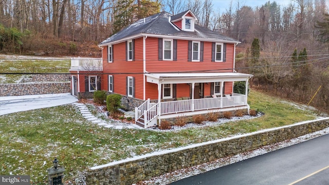 view of front of home with a porch and a front lawn