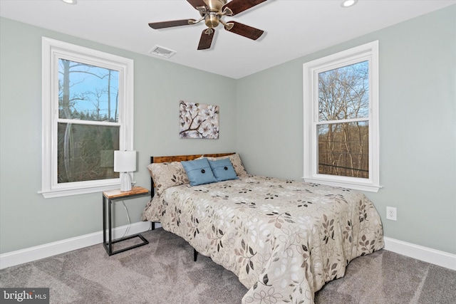 carpeted bedroom with ceiling fan and multiple windows