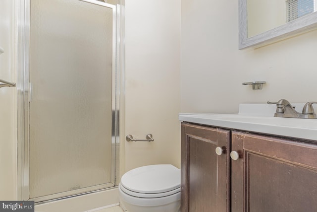 bathroom with an enclosed shower, vanity, and toilet