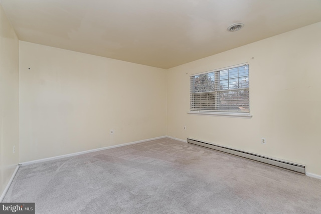 spare room featuring light carpet and a baseboard radiator