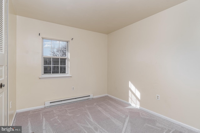 carpeted empty room featuring baseboard heating