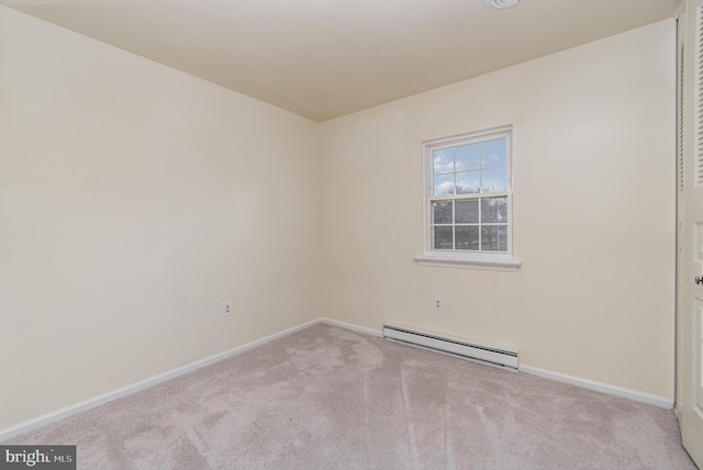 carpeted empty room featuring a baseboard heating unit