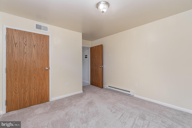 unfurnished bedroom featuring light colored carpet, baseboard heating, and a closet