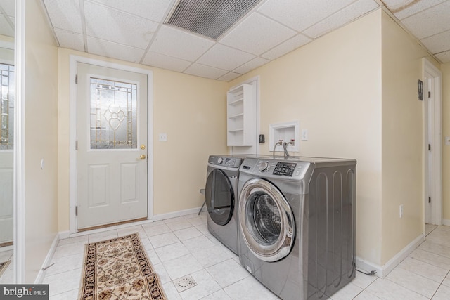 laundry area featuring light tile patterned floors and washing machine and dryer