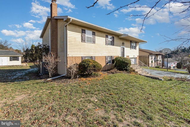 view of front of property with a front yard and central AC unit