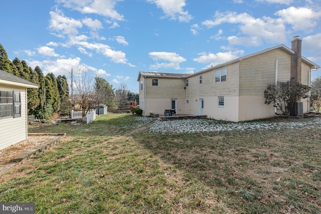 back of house with a lawn and cooling unit