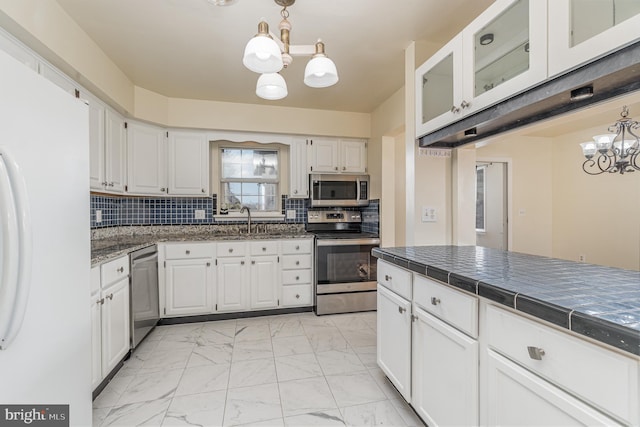 kitchen with sink, white cabinets, stainless steel appliances, and a notable chandelier