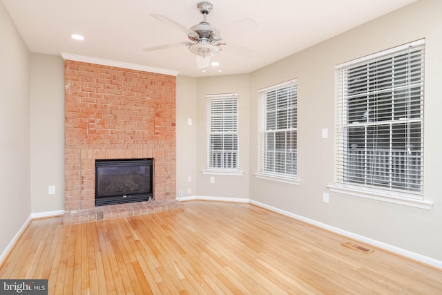 unfurnished living room with ceiling fan, light wood-type flooring, and a fireplace