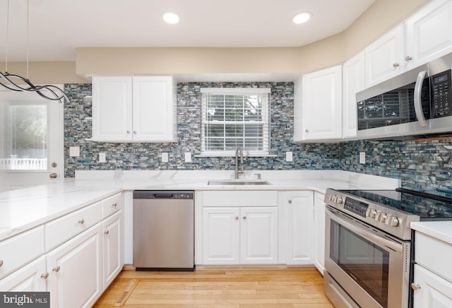 kitchen featuring appliances with stainless steel finishes, white cabinetry, and sink