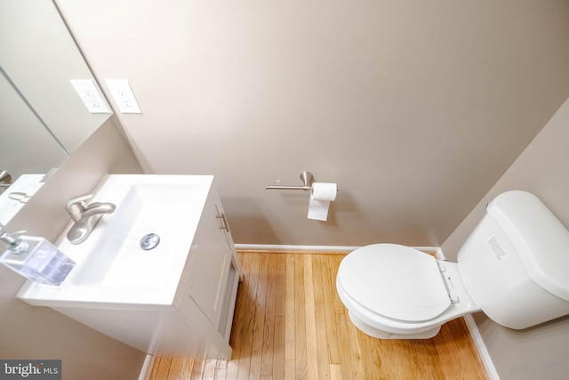 bathroom with wood-type flooring, vanity, and toilet