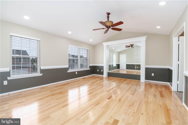 unfurnished living room with ceiling fan, light wood-type flooring, and vaulted ceiling