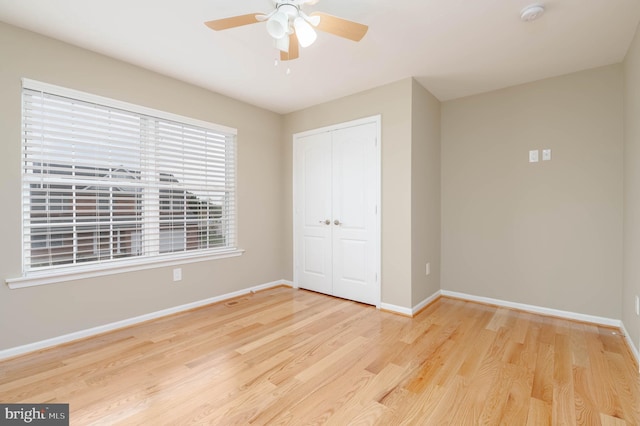 unfurnished bedroom featuring light hardwood / wood-style flooring, a closet, and ceiling fan