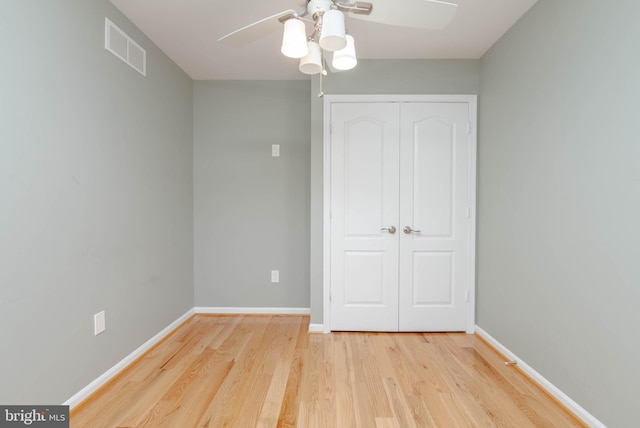 unfurnished bedroom with ceiling fan, a closet, and light hardwood / wood-style floors