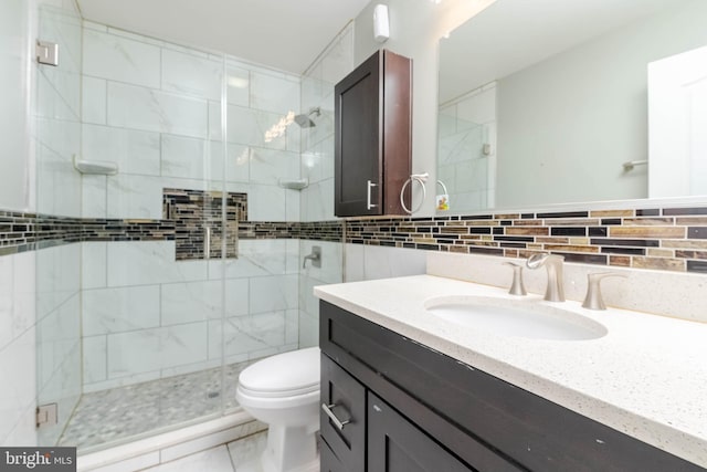 bathroom featuring vanity, a shower with door, toilet, and tile walls