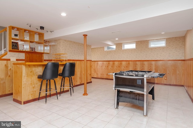 game room with wooden walls and indoor bar