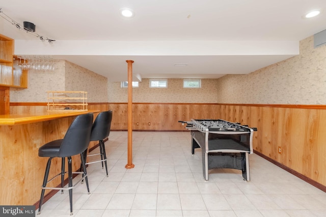 game room with bar and wood walls