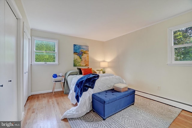 bedroom featuring a closet, light hardwood / wood-style flooring, and multiple windows