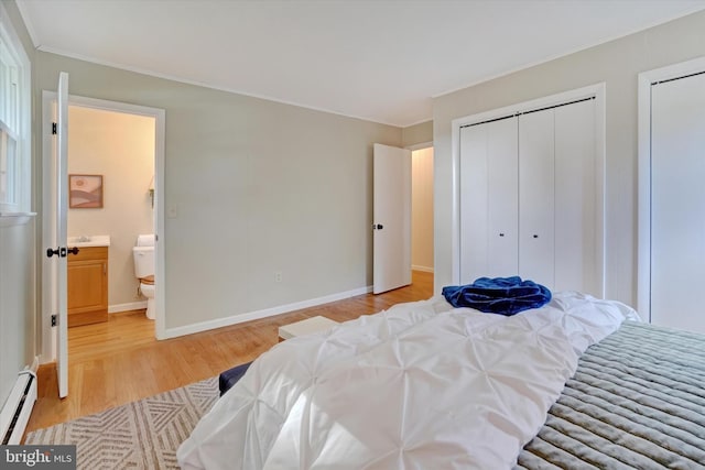 bedroom featuring light hardwood / wood-style floors, ensuite bath, and baseboard heating