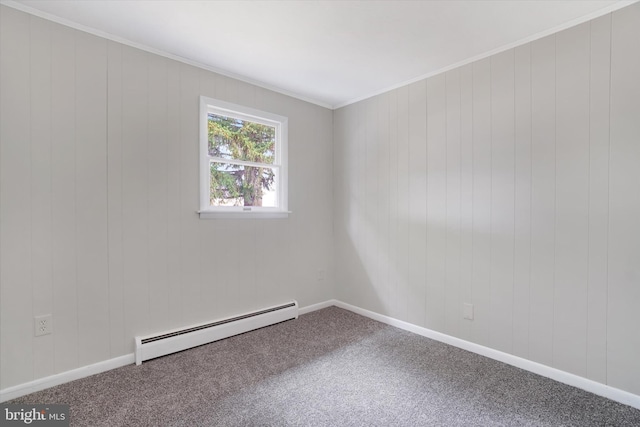 carpeted spare room with baseboard heating, wooden walls, and ornamental molding