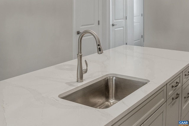 details featuring light stone countertops and sink