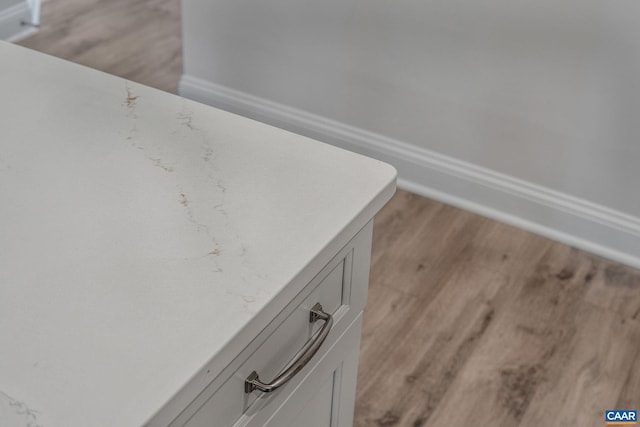 interior details featuring white cabinets and light wood-type flooring