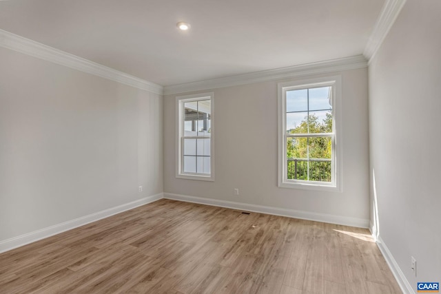 spare room with light hardwood / wood-style flooring and crown molding