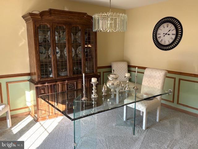 unfurnished dining area featuring carpet floors and a notable chandelier