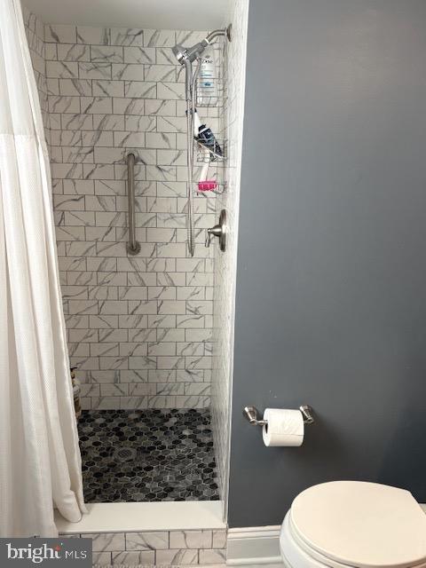 bathroom featuring a shower with curtain and toilet