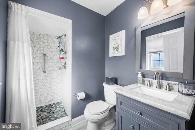 bathroom featuring a shower with shower curtain, vanity, and toilet