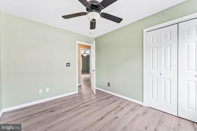 unfurnished bedroom featuring ceiling fan, light hardwood / wood-style flooring, and a closet