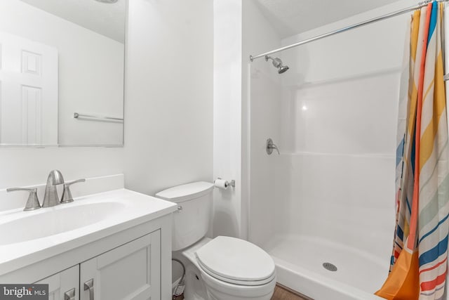 bathroom featuring a shower with shower curtain, vanity, toilet, and a textured ceiling