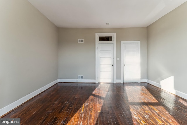 unfurnished room with dark hardwood / wood-style flooring