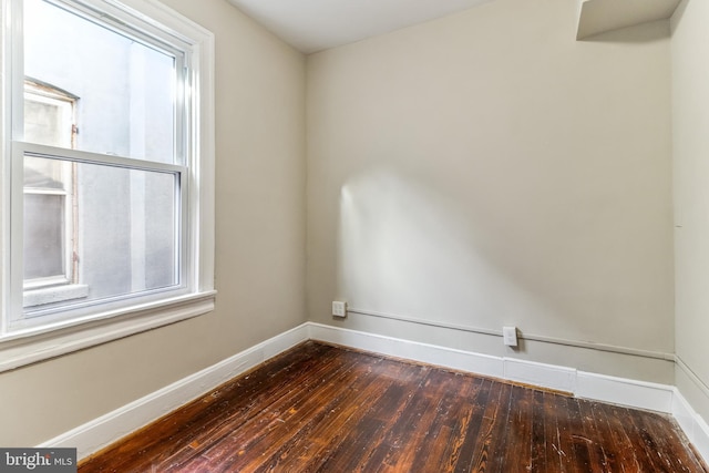 spare room featuring plenty of natural light and dark wood-type flooring