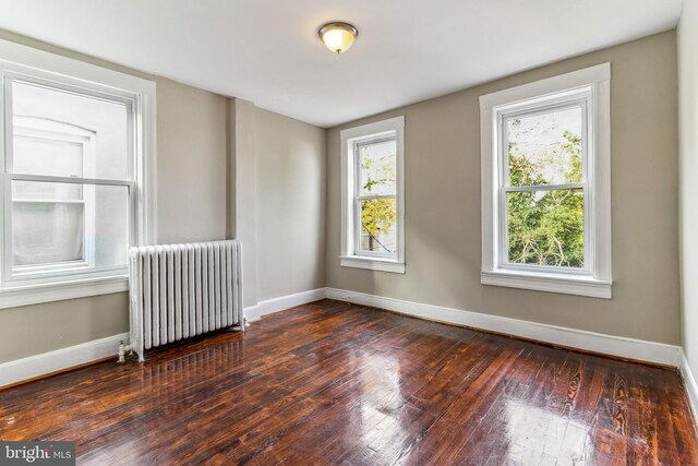 unfurnished room featuring dark wood-type flooring and radiator