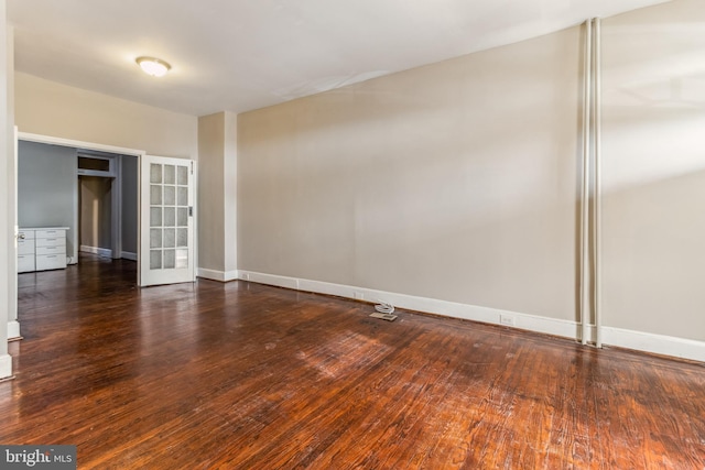 empty room featuring french doors and dark hardwood / wood-style floors