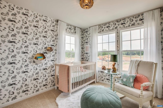 bedroom with carpet flooring, multiple windows, and a crib