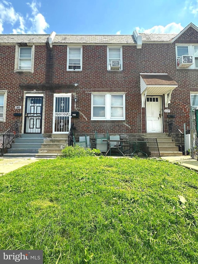 view of property with cooling unit and a front lawn