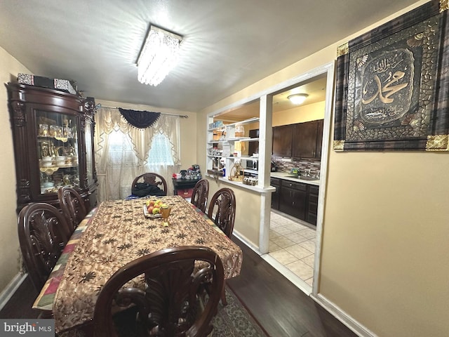 dining room with light hardwood / wood-style floors, an inviting chandelier, and sink